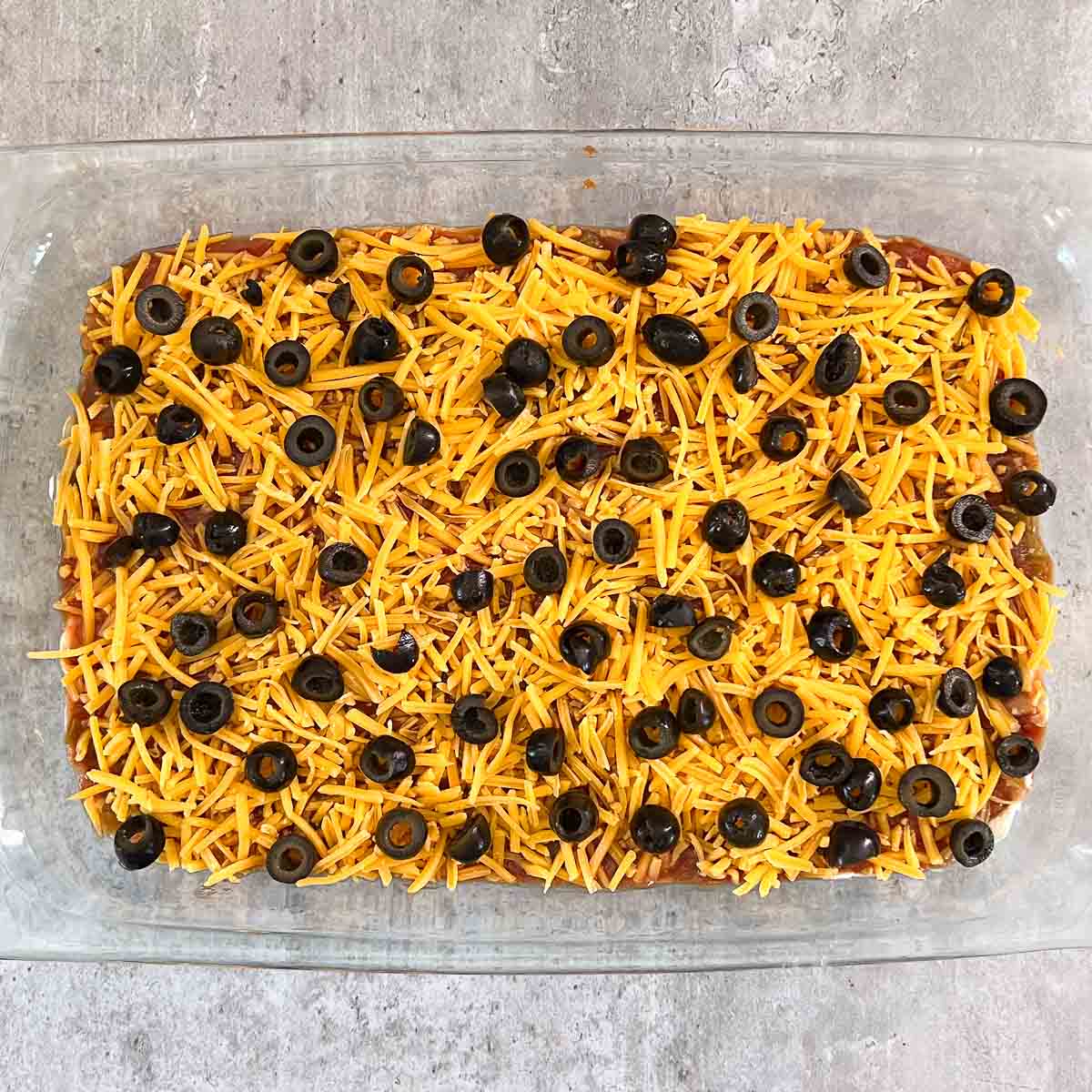 black olives spread over shredded cheese