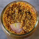 closeup of pickled mustard seeds with chopped shallot mixed in
