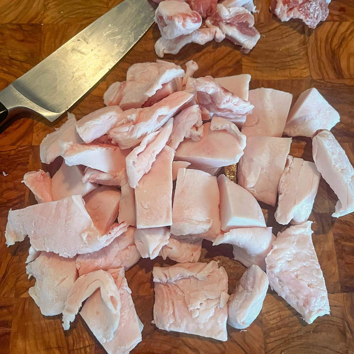 cubed pork fat on a cutting board