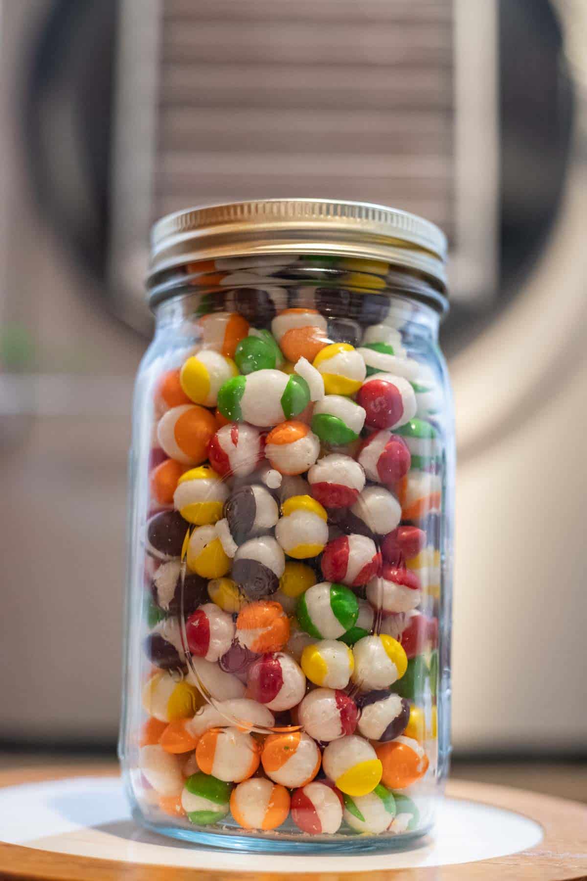 freeze dried skittles in a jar in front of a freeze dryer