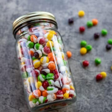 jar of freeze dried skittles with more around it