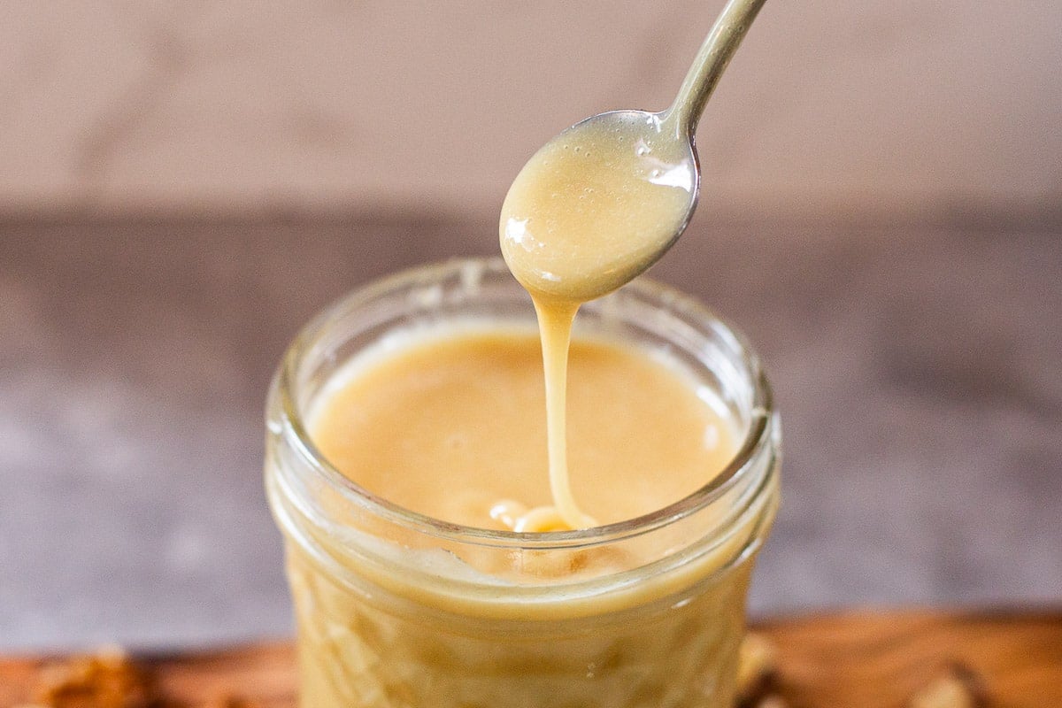 spoon drizzling whipped honey (creamed honey) into mason jar