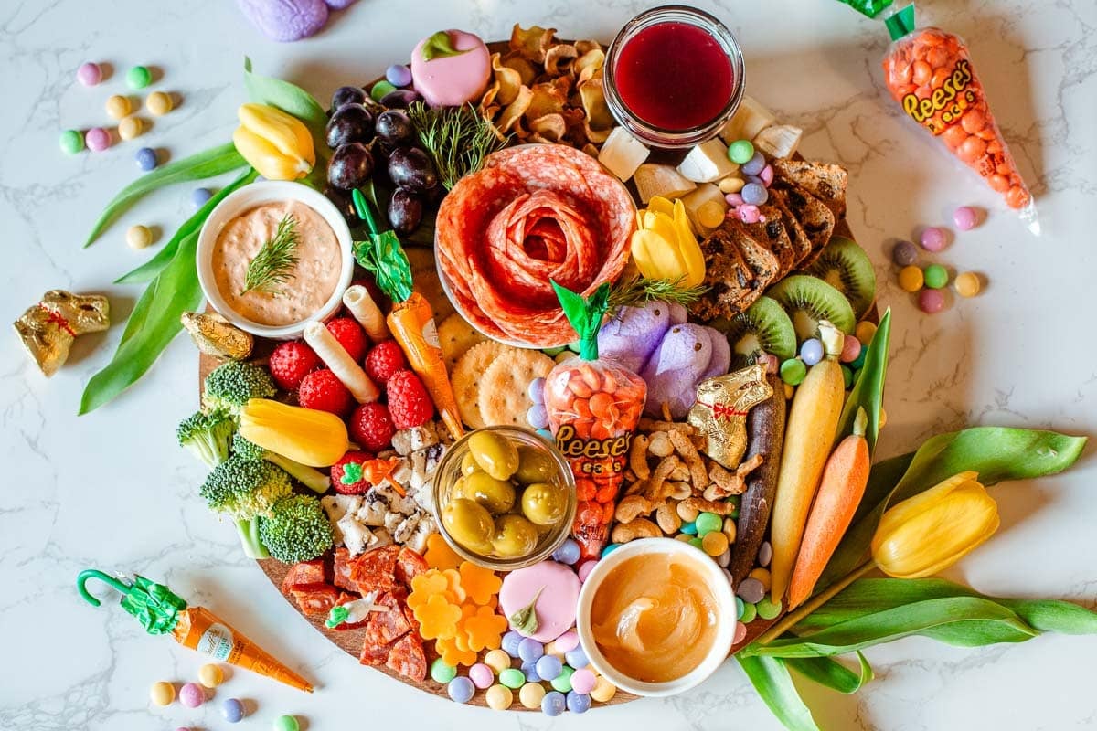 easter charcuterie board surrounded by loose Easter candies