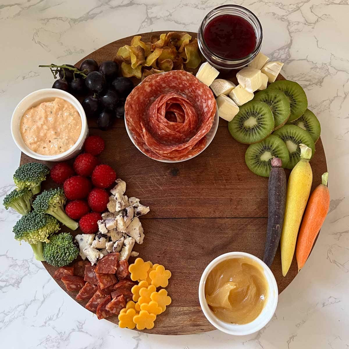 cheeses meats and fruits added to board