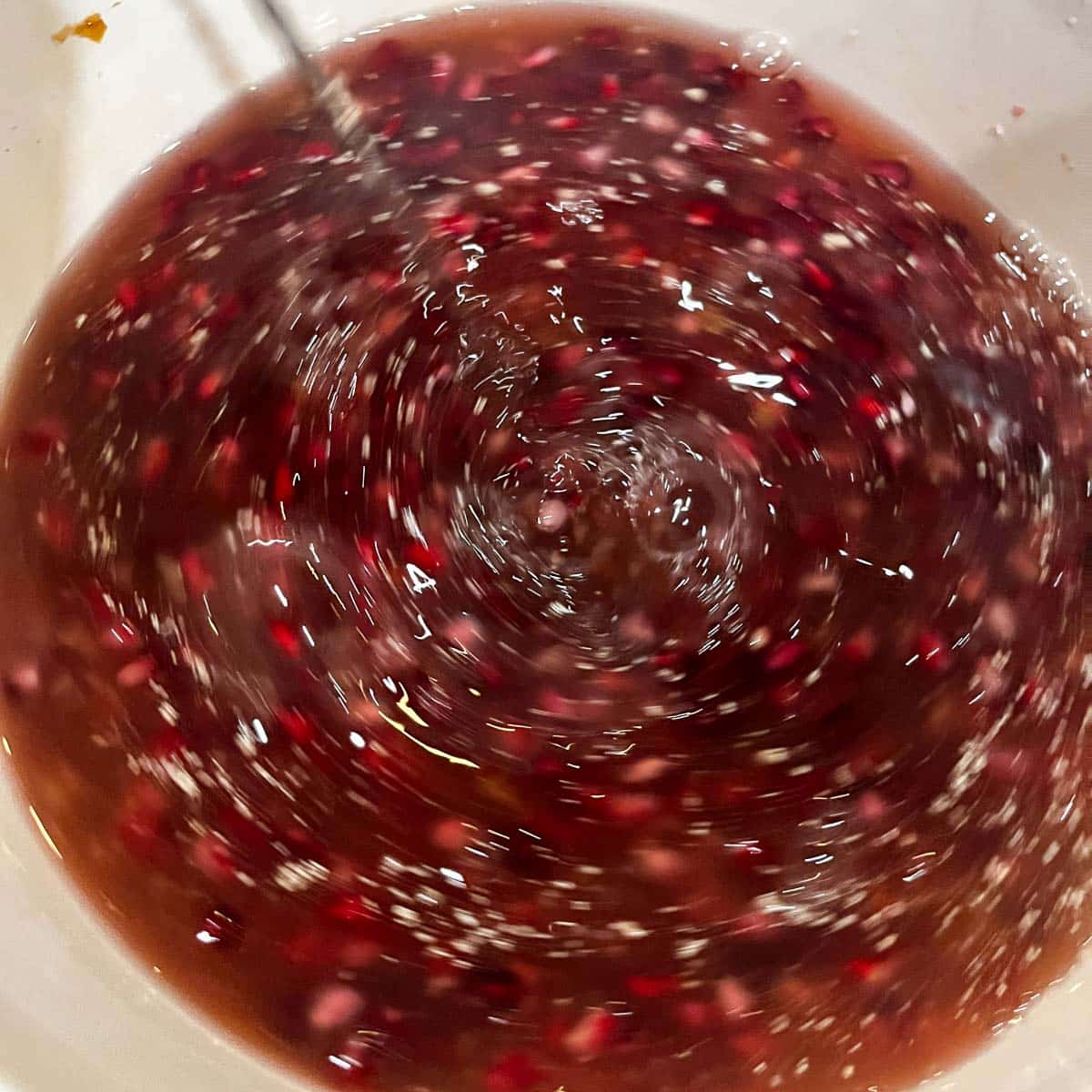 stirring adding chemicals to pomegranate wine must