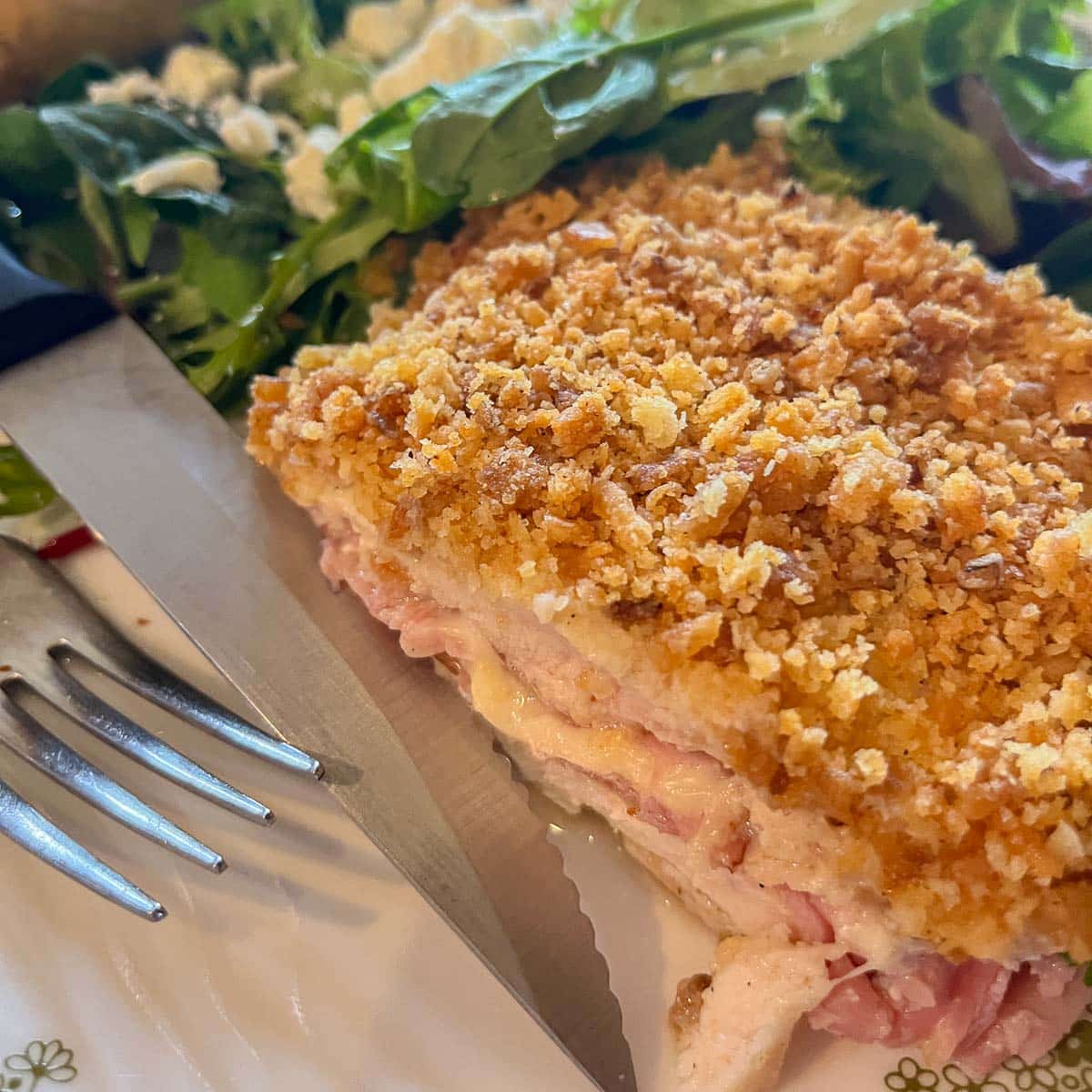 chicken cordon bleu casserole slice on a plate with salad