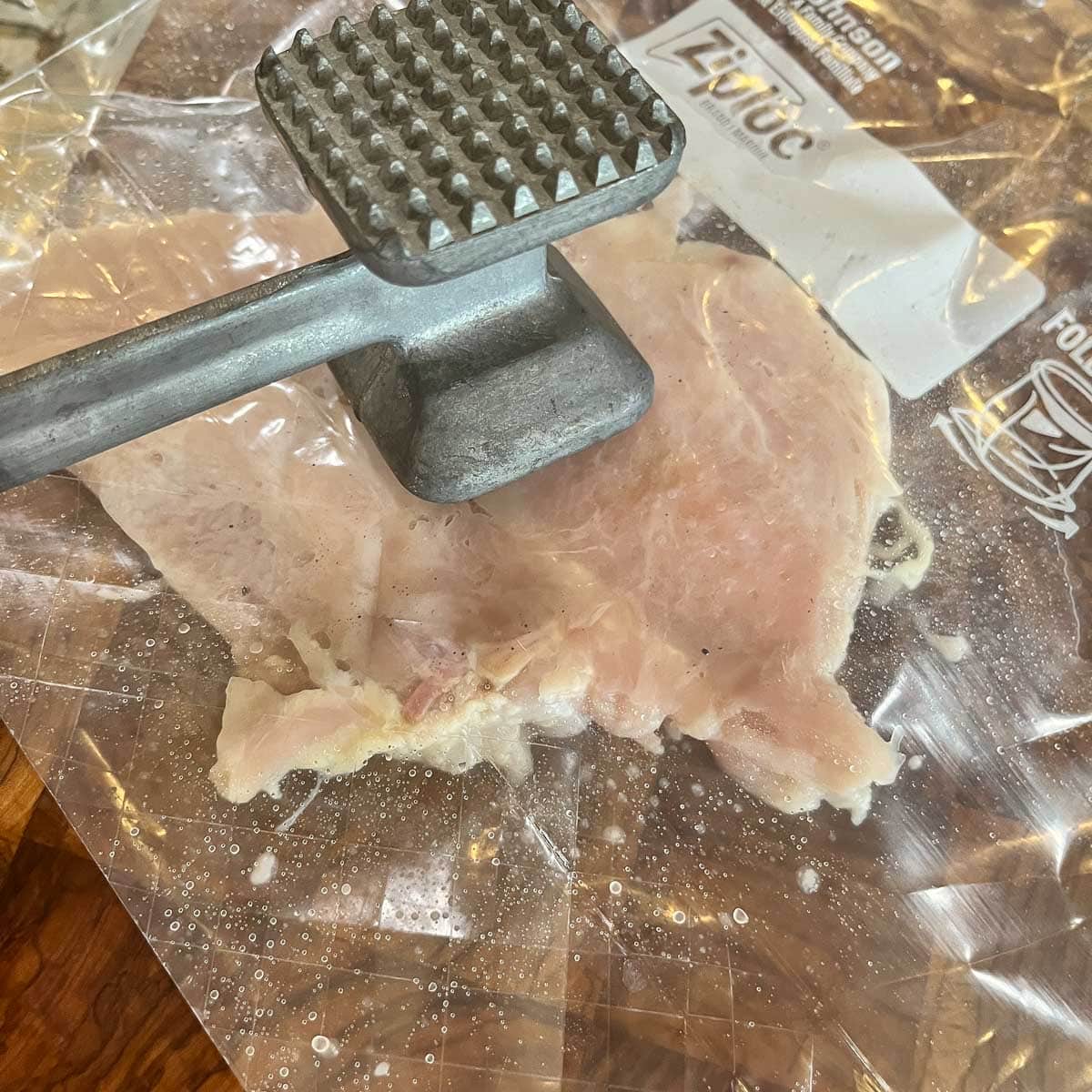 pounding chicken breast with mallet.