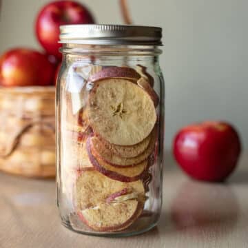 freeze dried apples in a jar with more apples around it