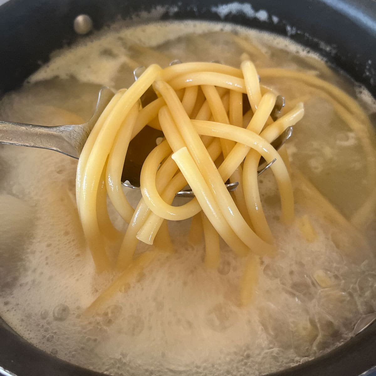 removing noodles from boiling water.