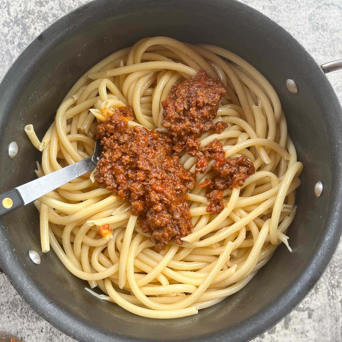 a pot of pastitsio noodles with meat sauce on them.