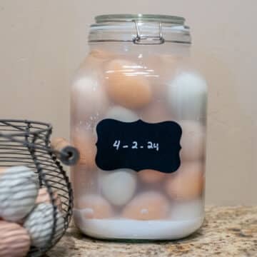 water glassed eggs in a gallon sized jar with more eggs in a basket