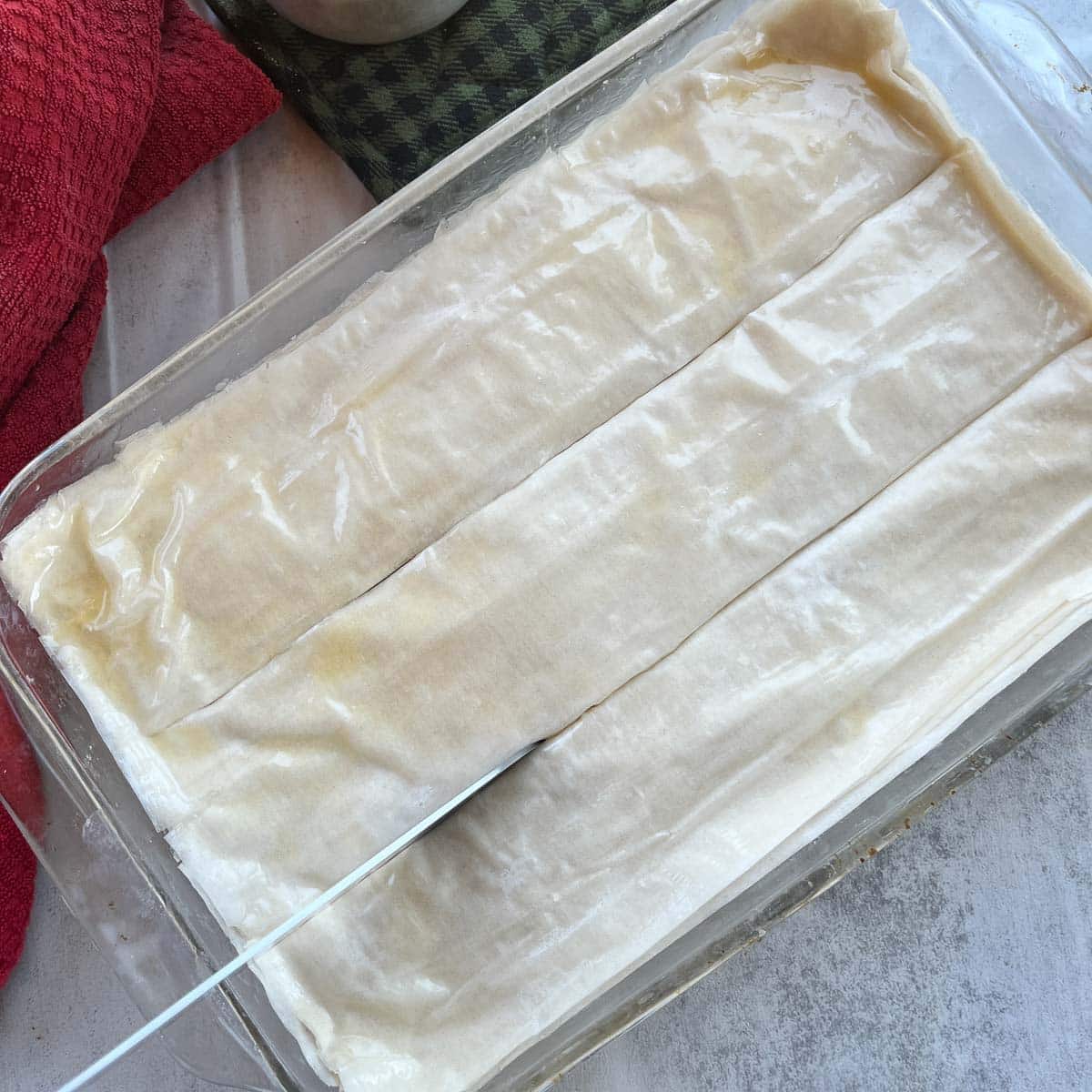 slicing unbaked Greek Galaktoboureko.