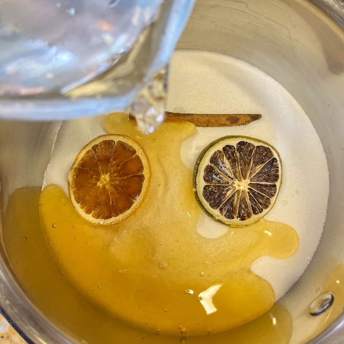 pouring water into pot of sugar and spices.