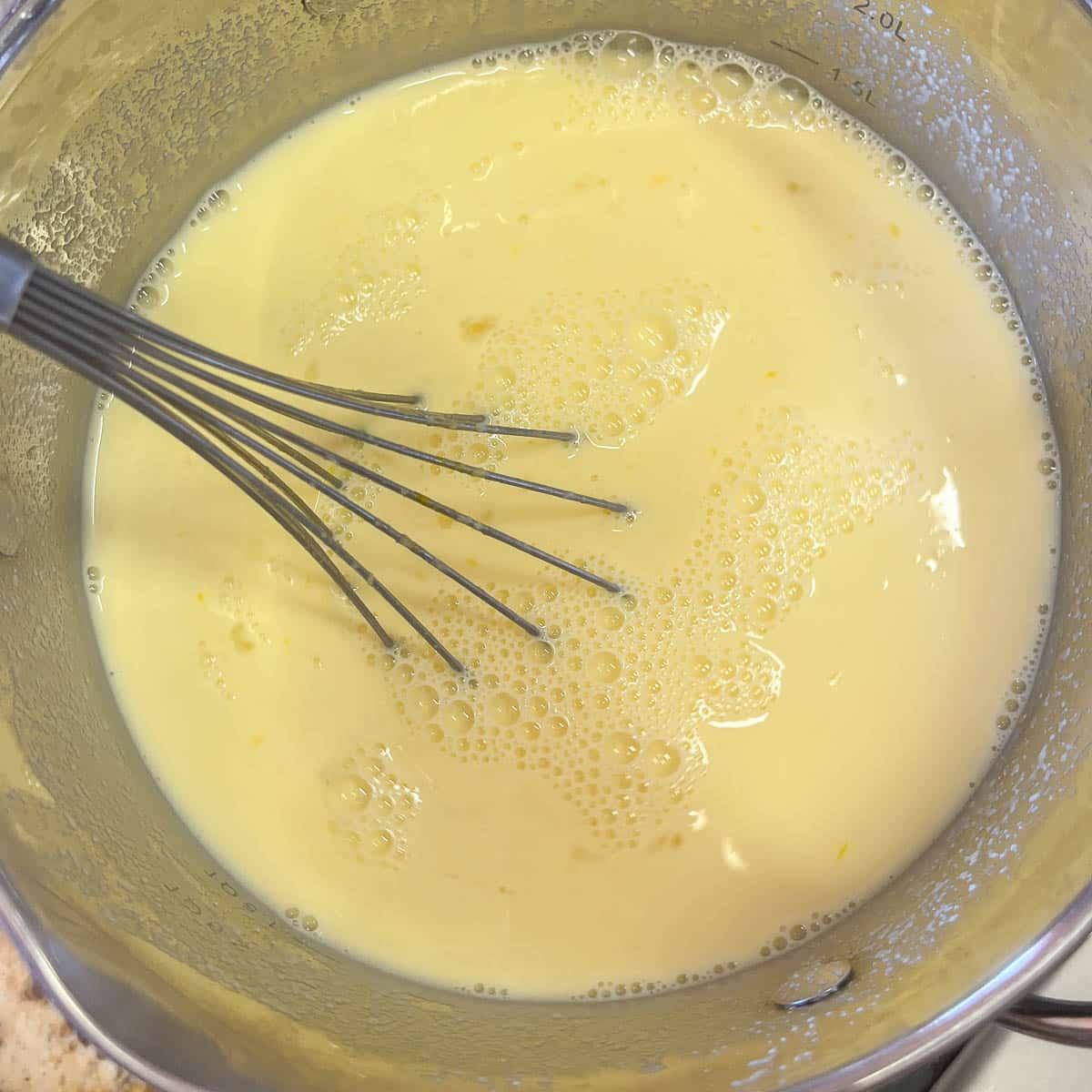 whisking custard in a small saucepan.