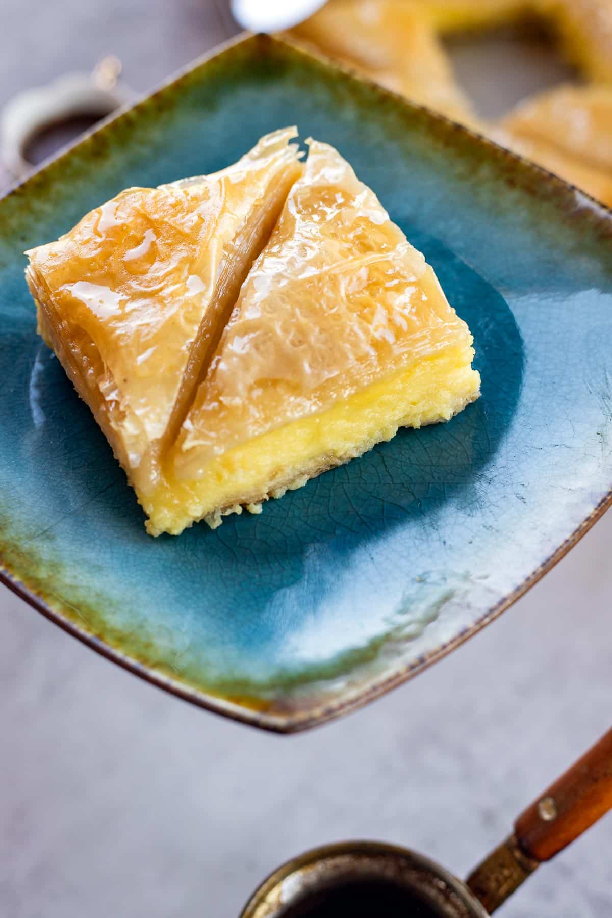 2 pieces of Greek Galaktoboureko on a blue plate.