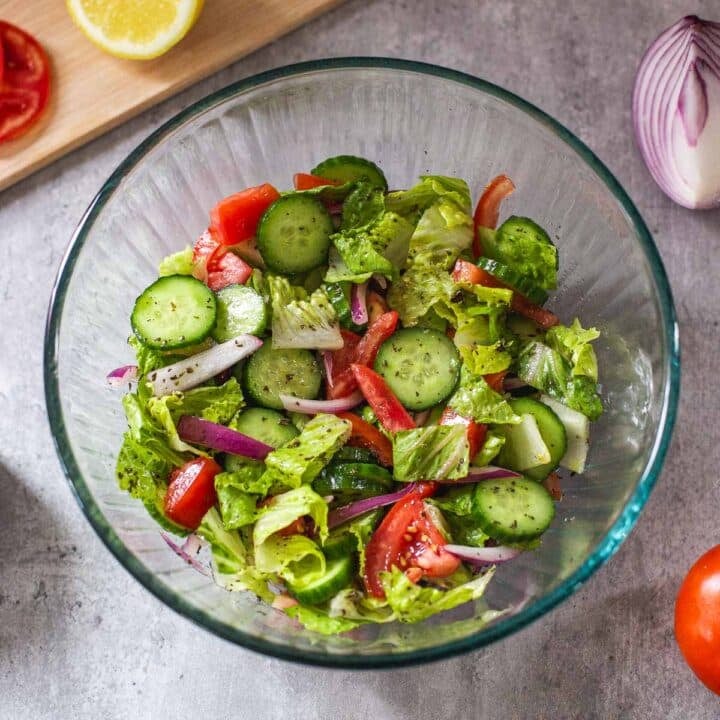 middle eastern salad in bowl surrounded by vegetables