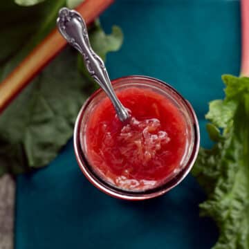 top view of rhubarb sauce in a jar with blue background