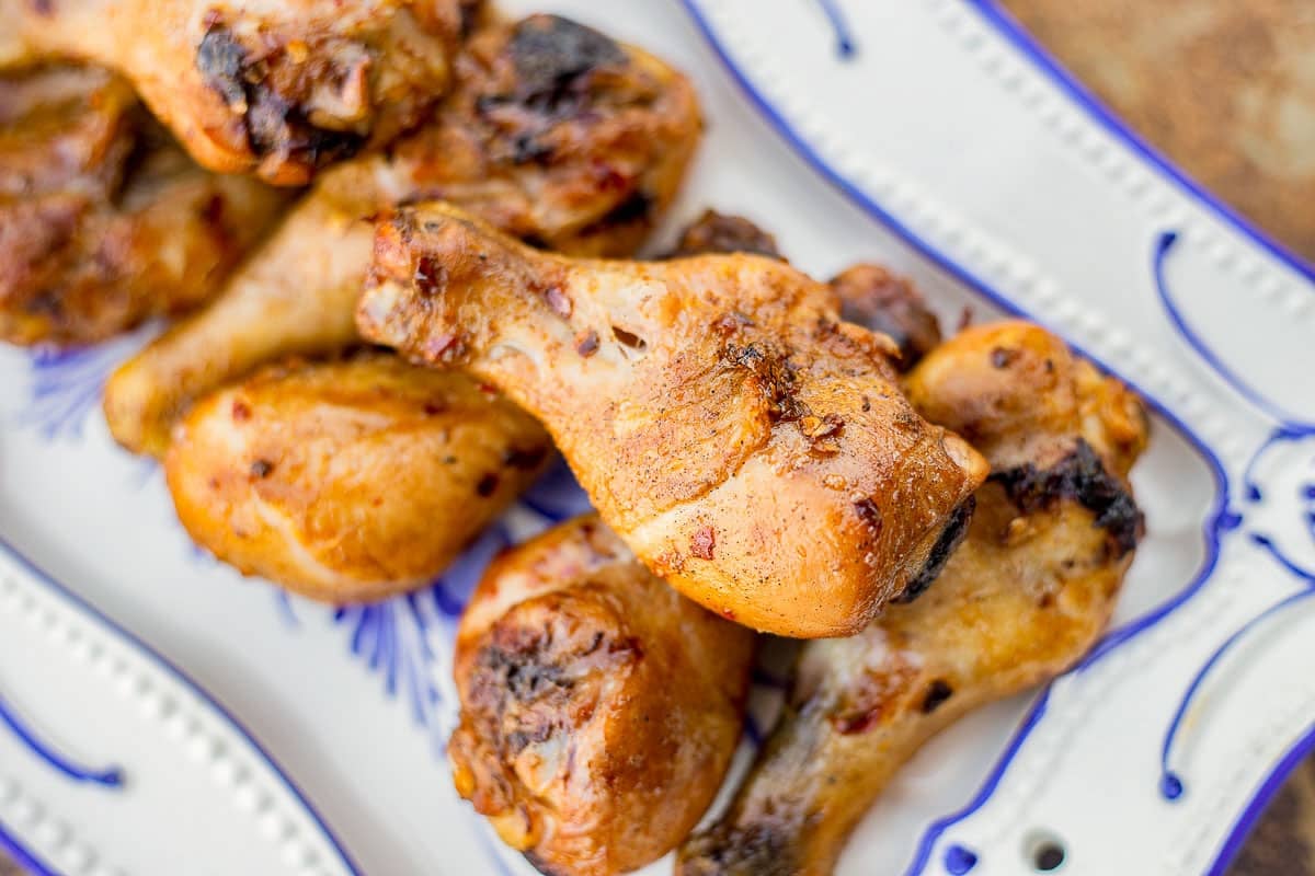 smoked chicken legs on a white and blue plate