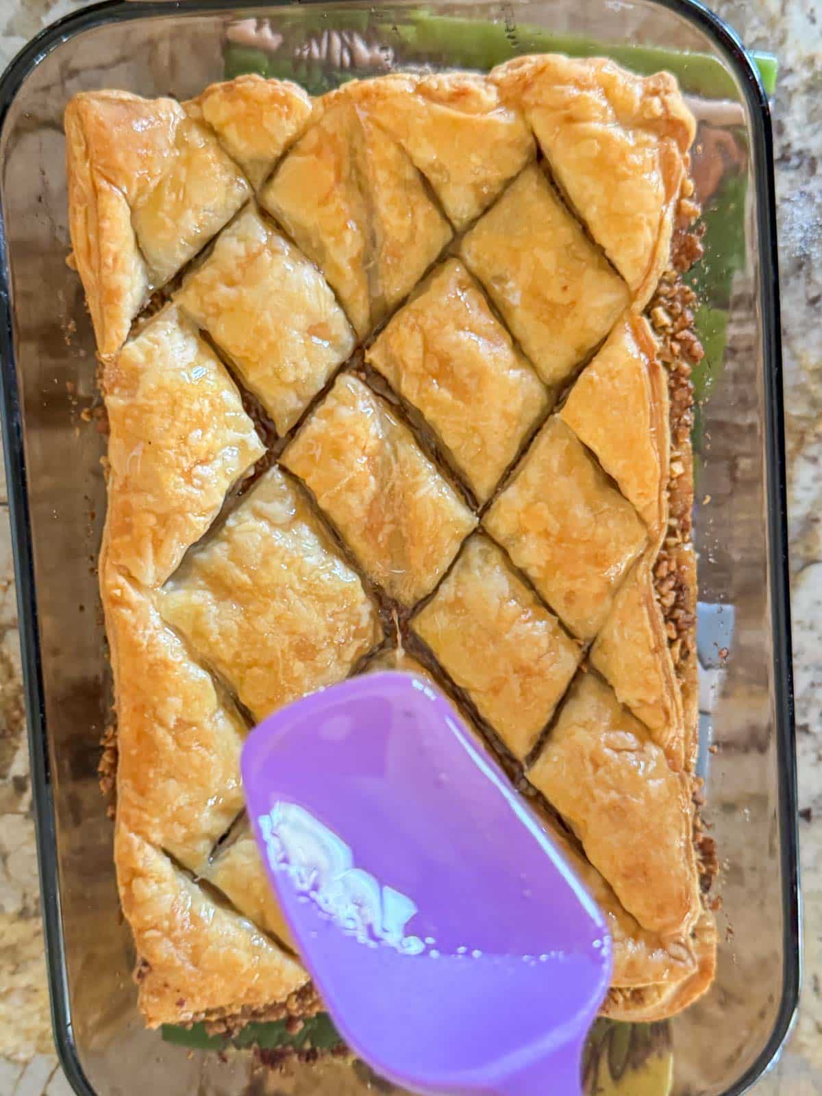 drizzling syrup on puff pastry baklava