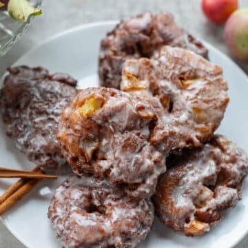 applesauce fritters on a plate with cinnamon sticks and apples