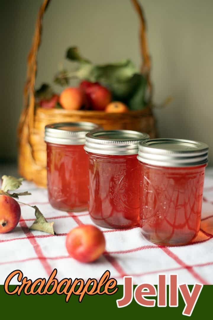 3 jars of crabapple jelly in front of a basket of crabapples