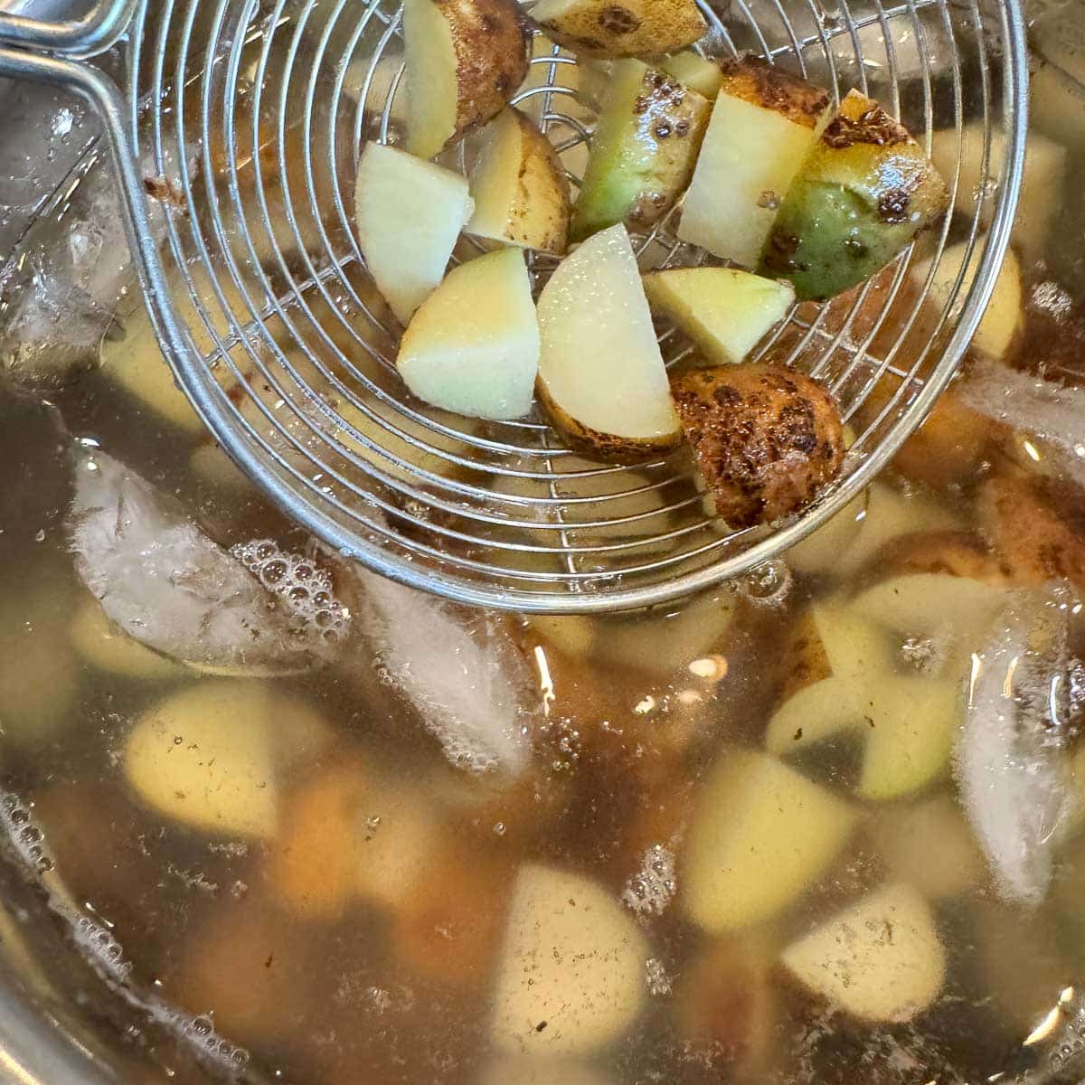 adding potatoes to ice water.
