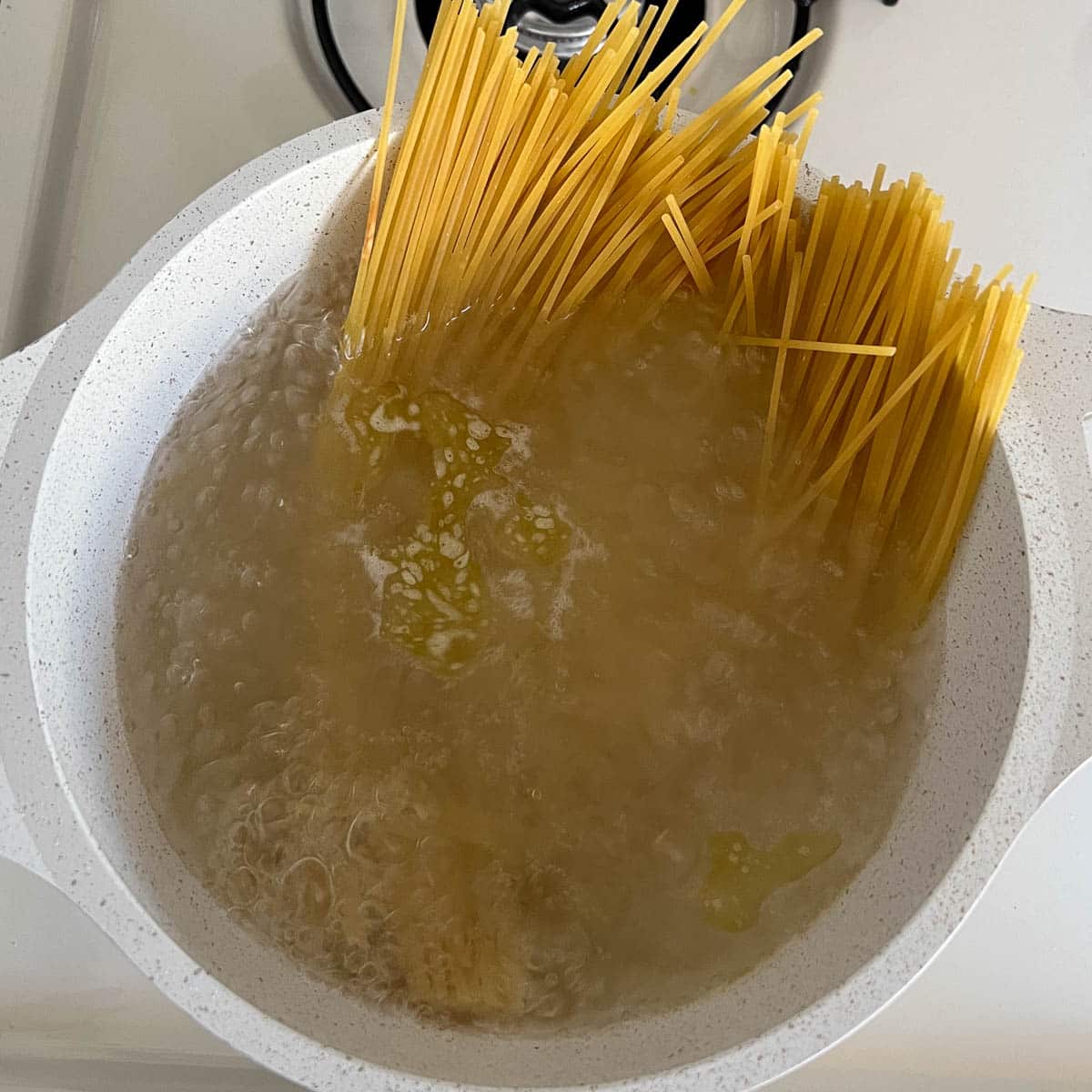 uncooked spaghetti noodles in boiling water