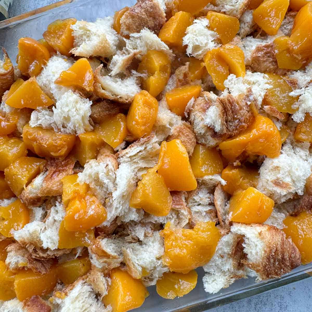 croissant chunks and peaches in a pan