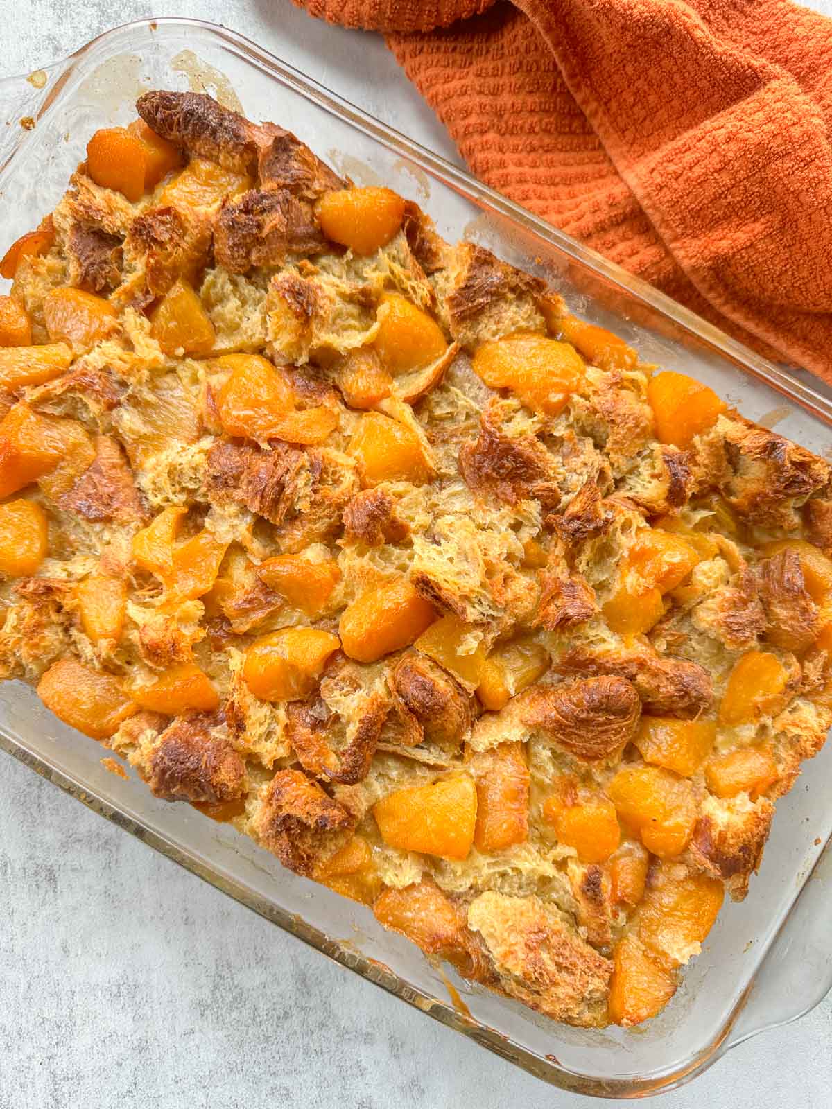 peach bread pudding with a an orange dishcloth