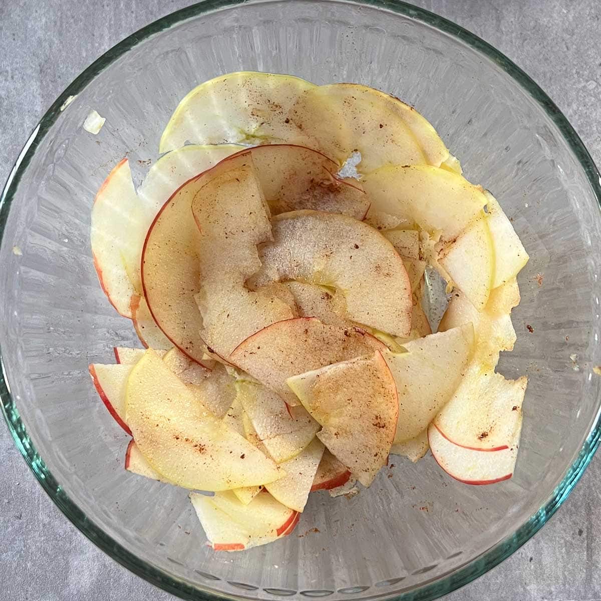 apple slices in bowl with lemon juice and cinnamon