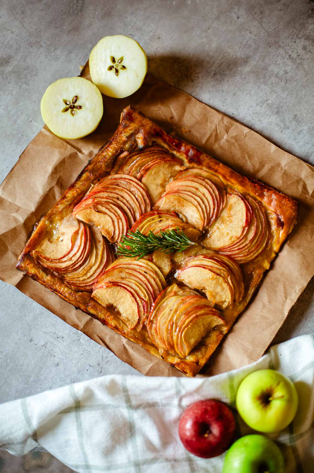 apple puff tart on brown paper beside apples