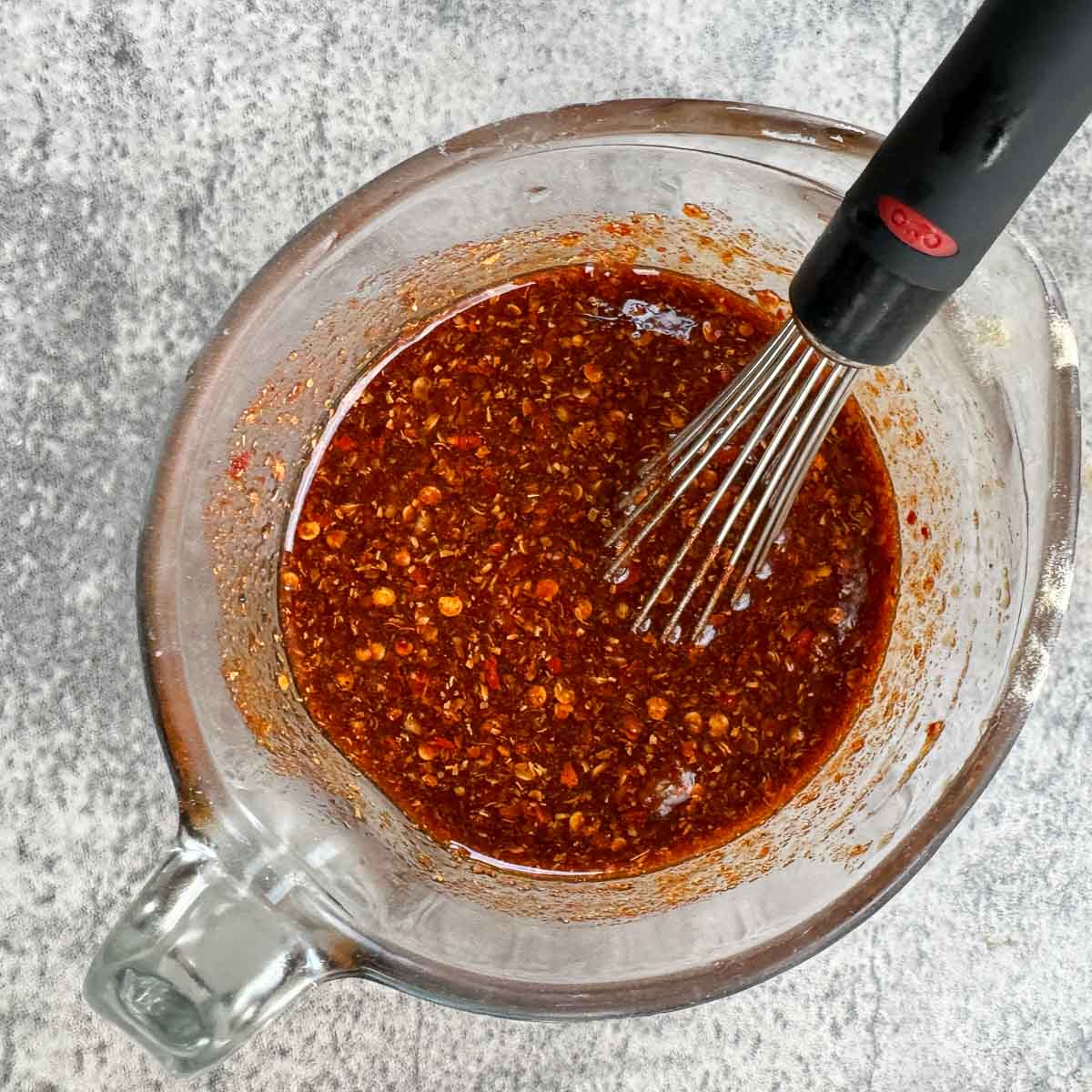 jerky marinade in a measuring cup with a whisk.