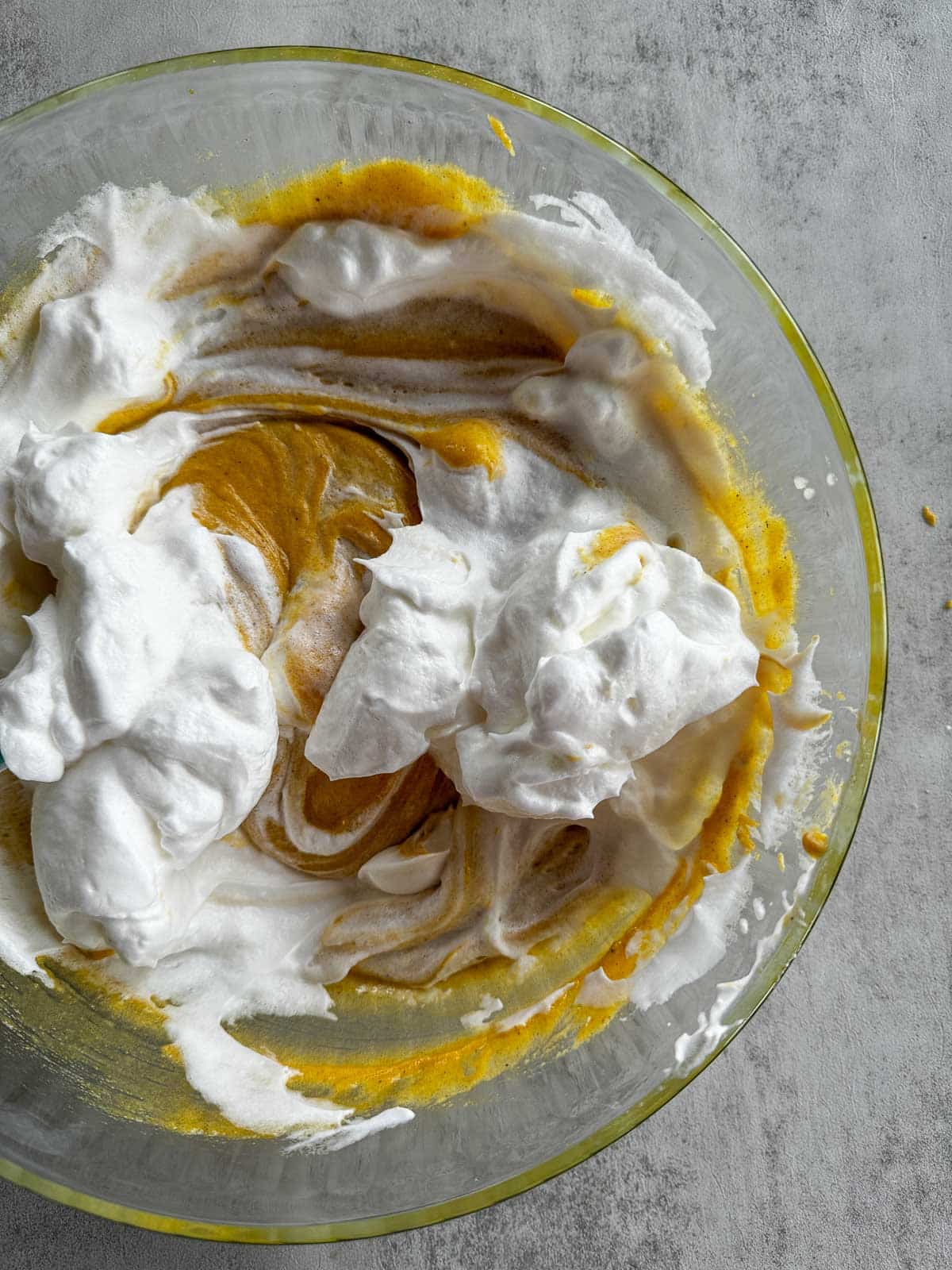 tom and jerry egg whites and yolk mixture being stirred together in a bowl.