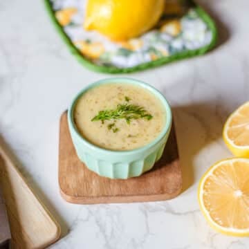 lemon and dill sauce beside herbs, lemon, knife.