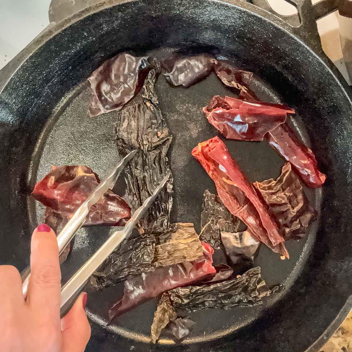 toasting dried chiles in a cast iron skillet.