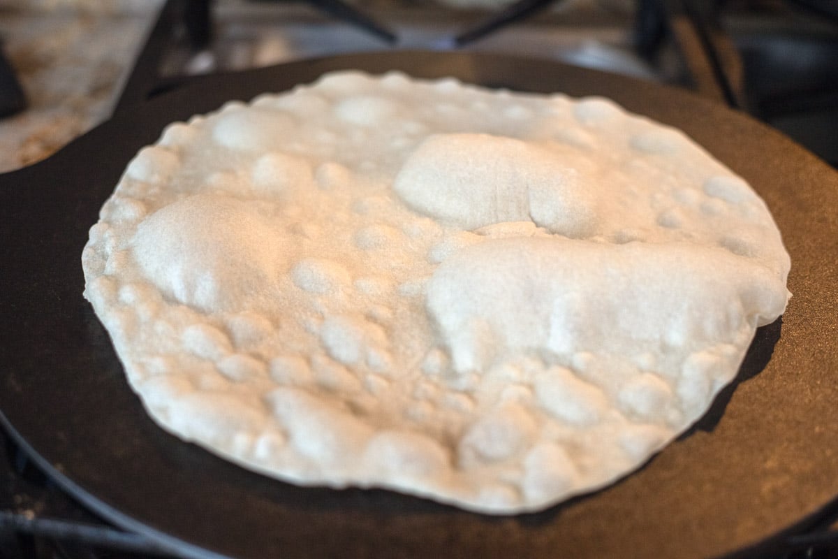 sourdough discard tortilla cooking on a skillet.