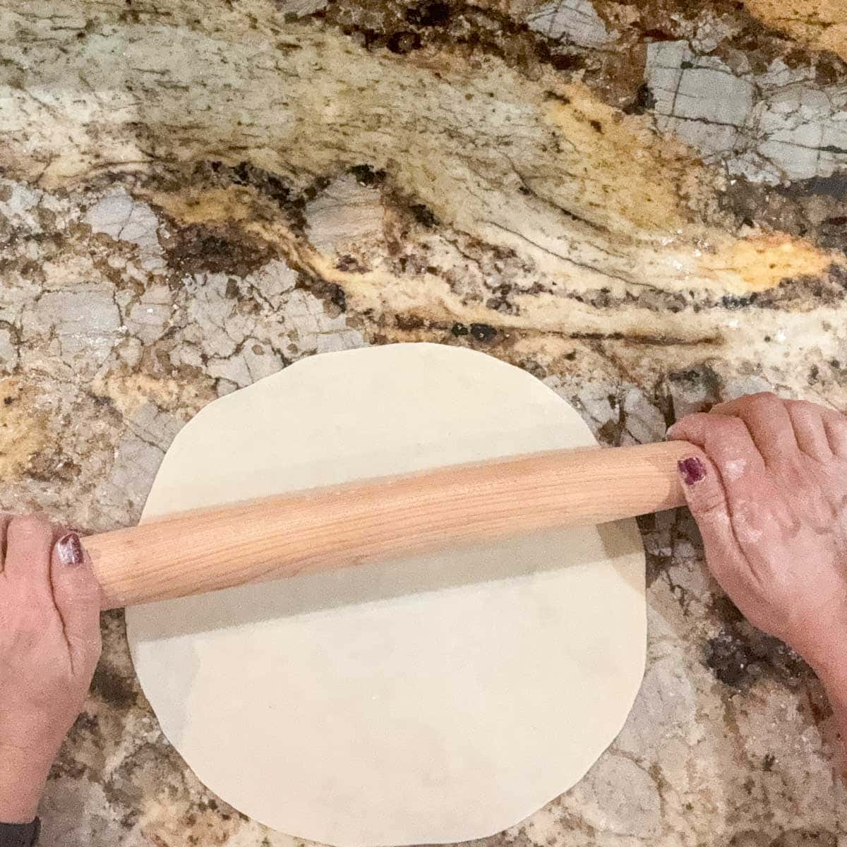 rolling out sourdough discard tortilla dough.