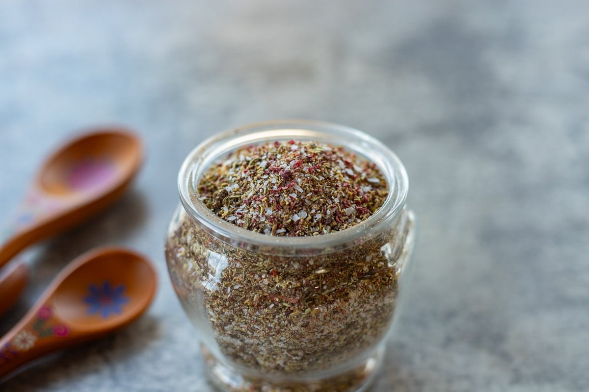 spices in a jar with some wooden spoons behind it.