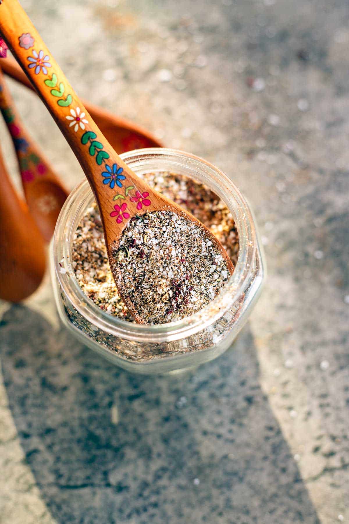 steak seasoning in a jar with a wooden spoon set .