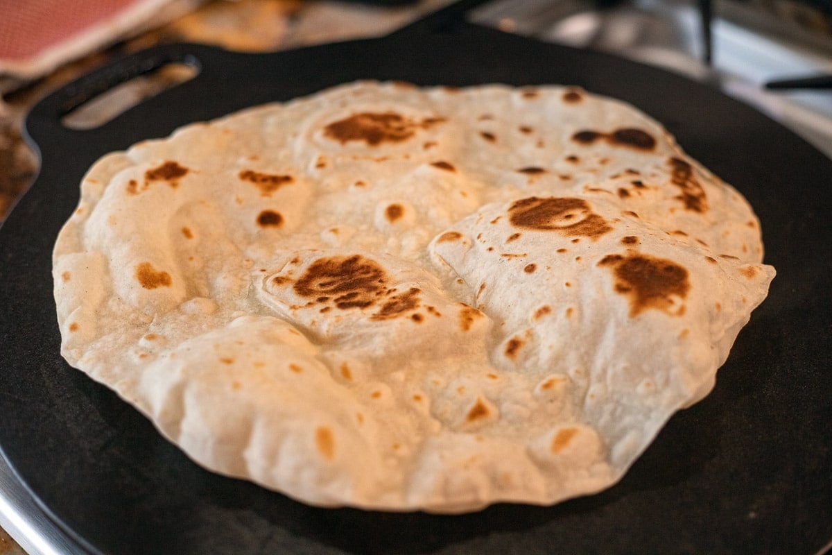 sourdough discard tortilla cooking on a skillet.