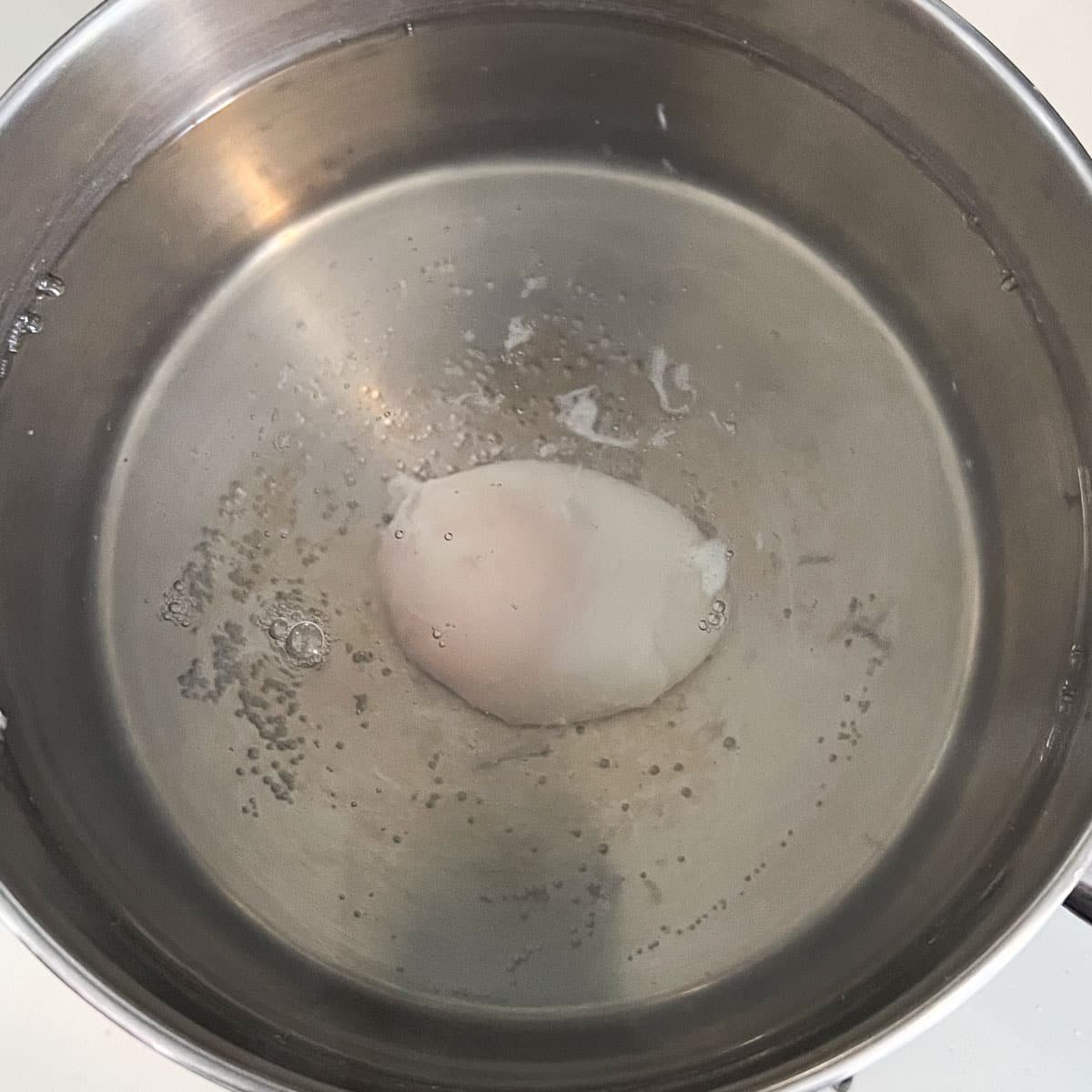 fully poached egg in the hot water.