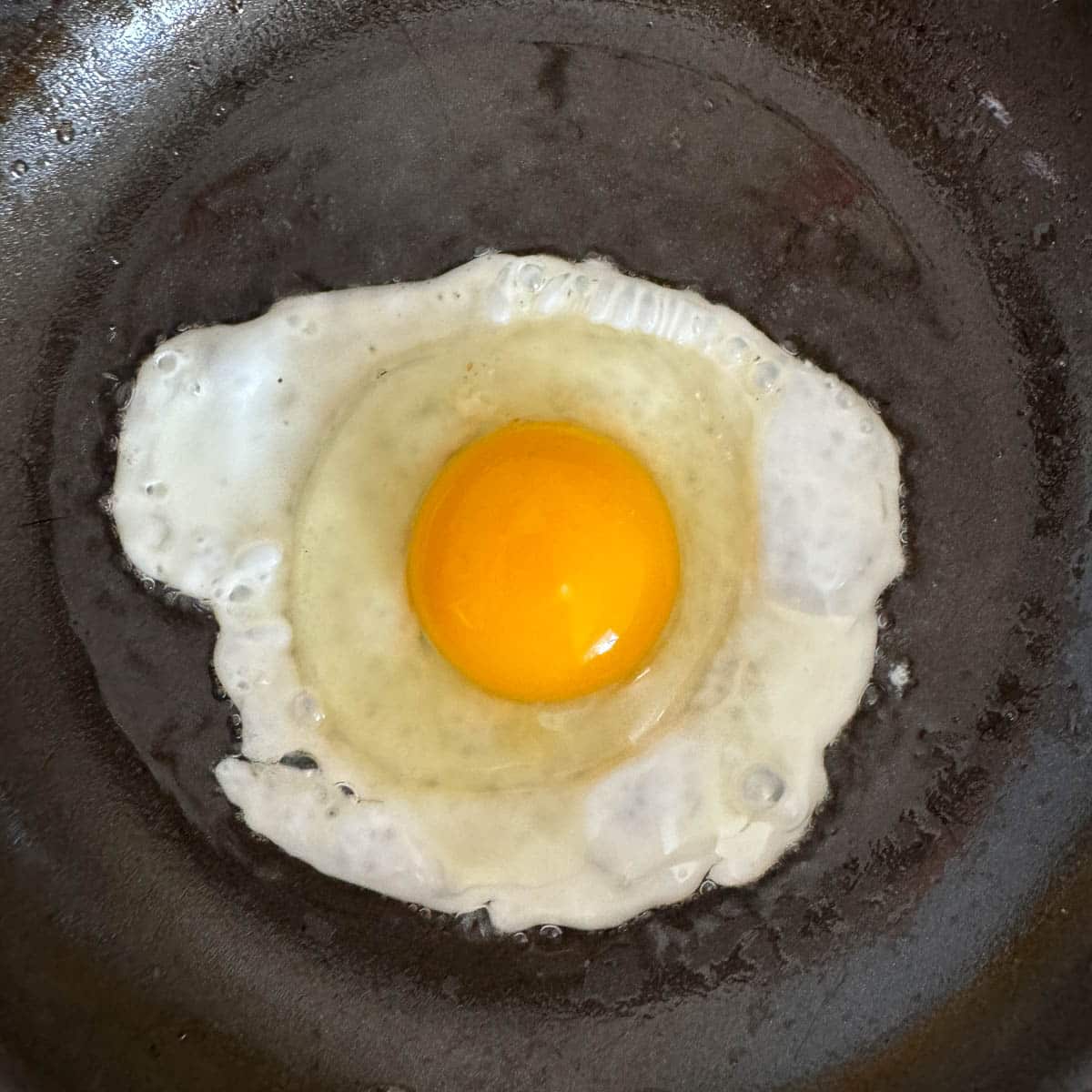 egg frying in a pan.