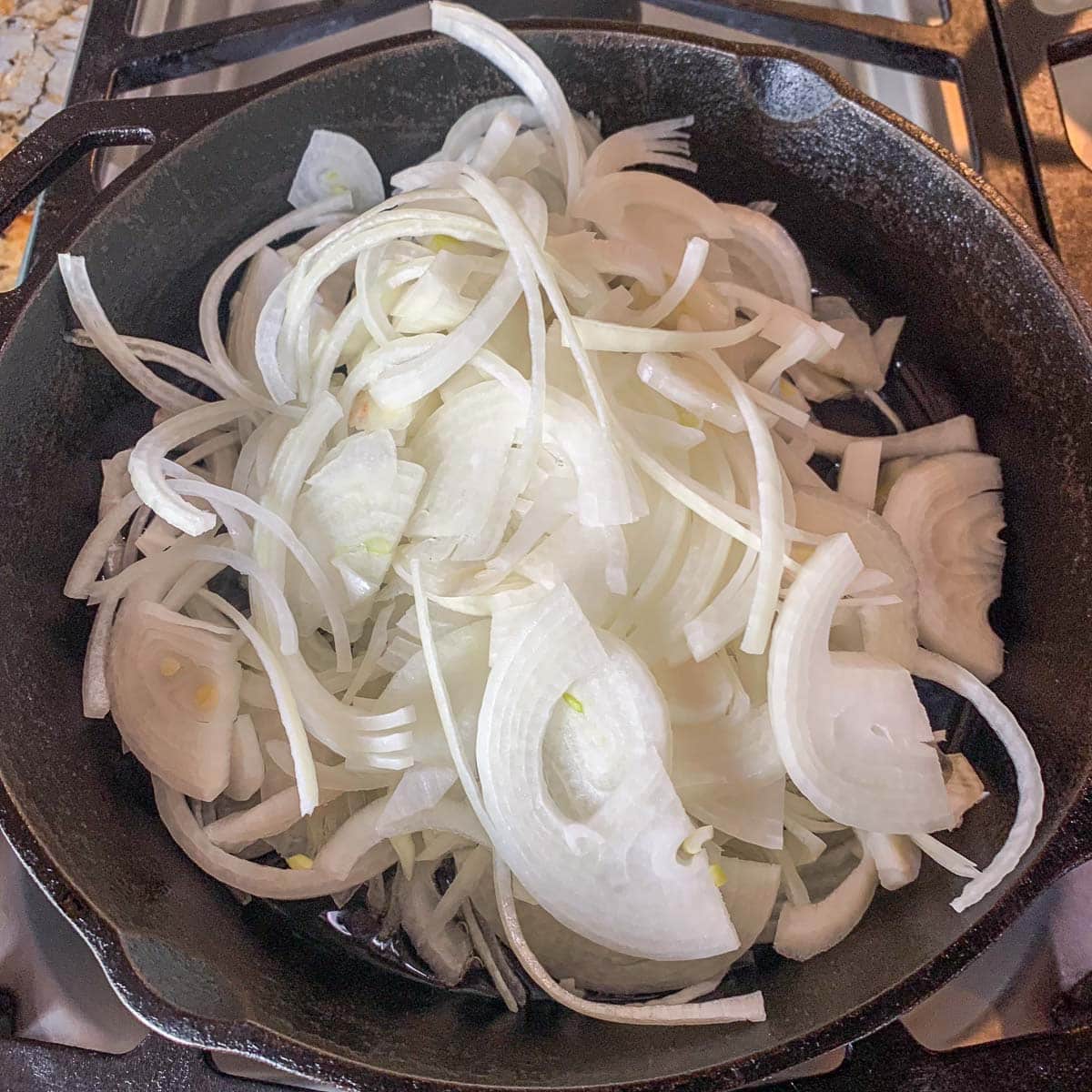 sliced onions in a cast iron skillet. 