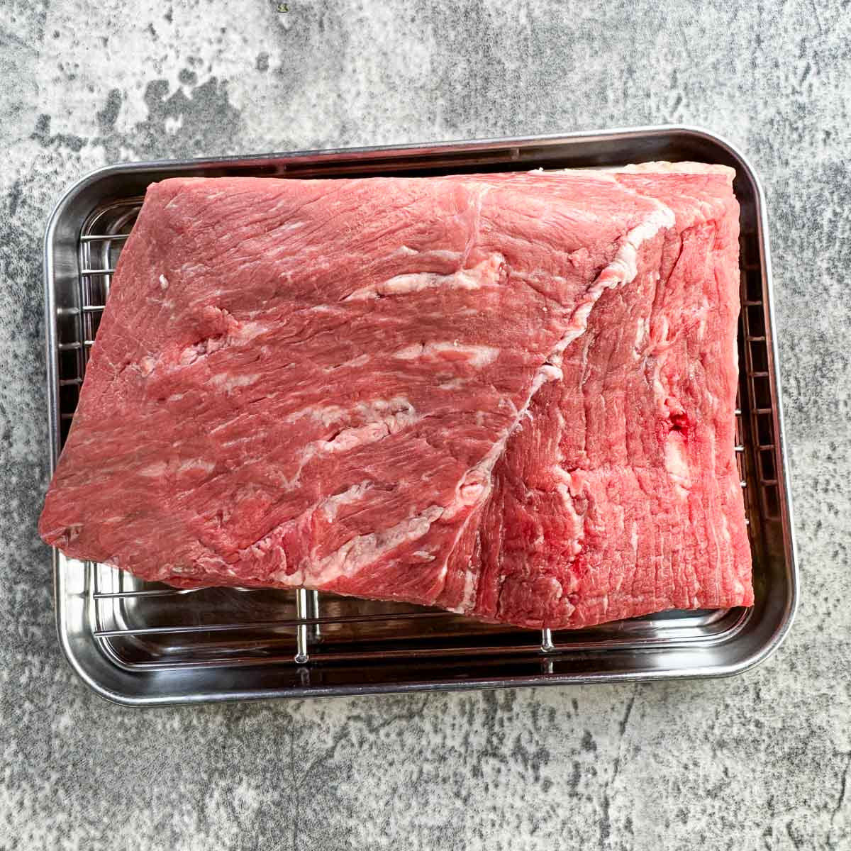 raw rump roast on a rack.