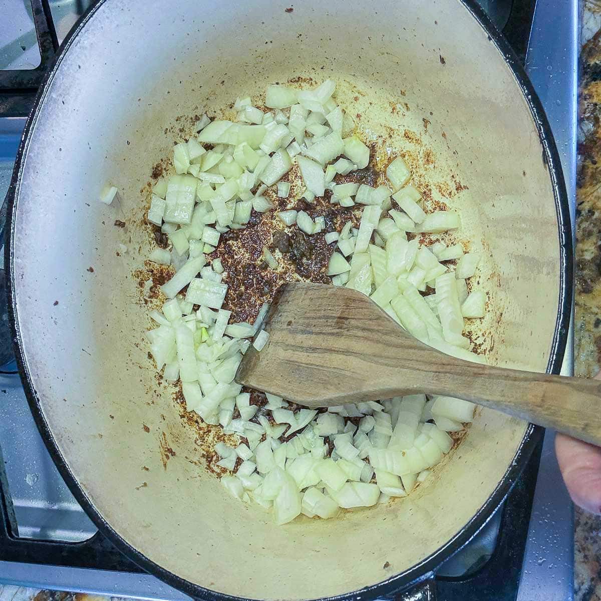 diced onions cooking in a pot.