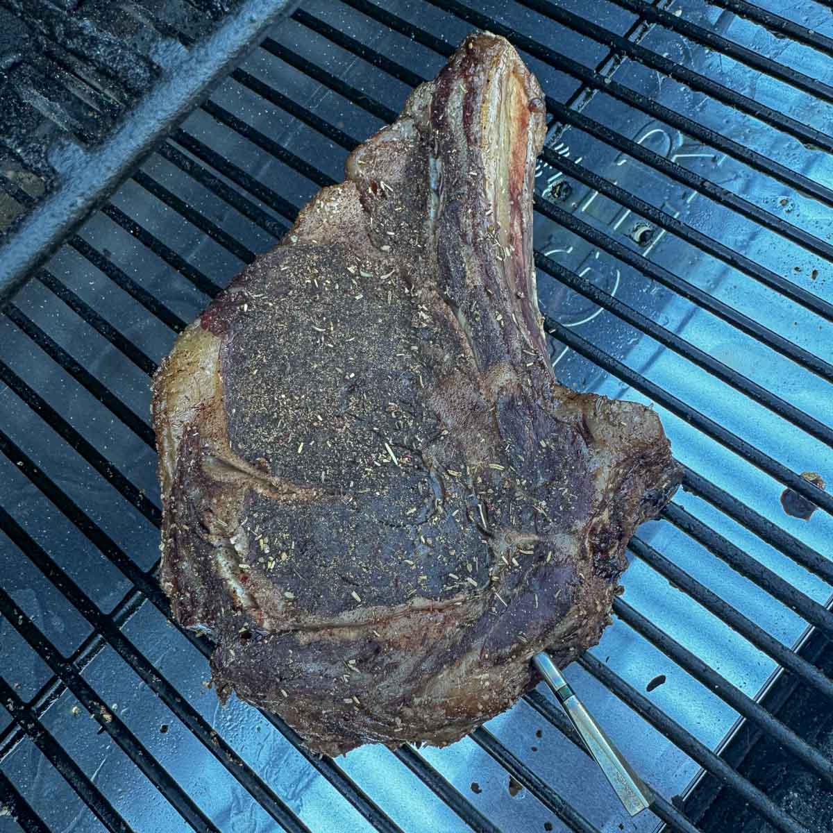 a smoked ribeye steak on a smoker grate.