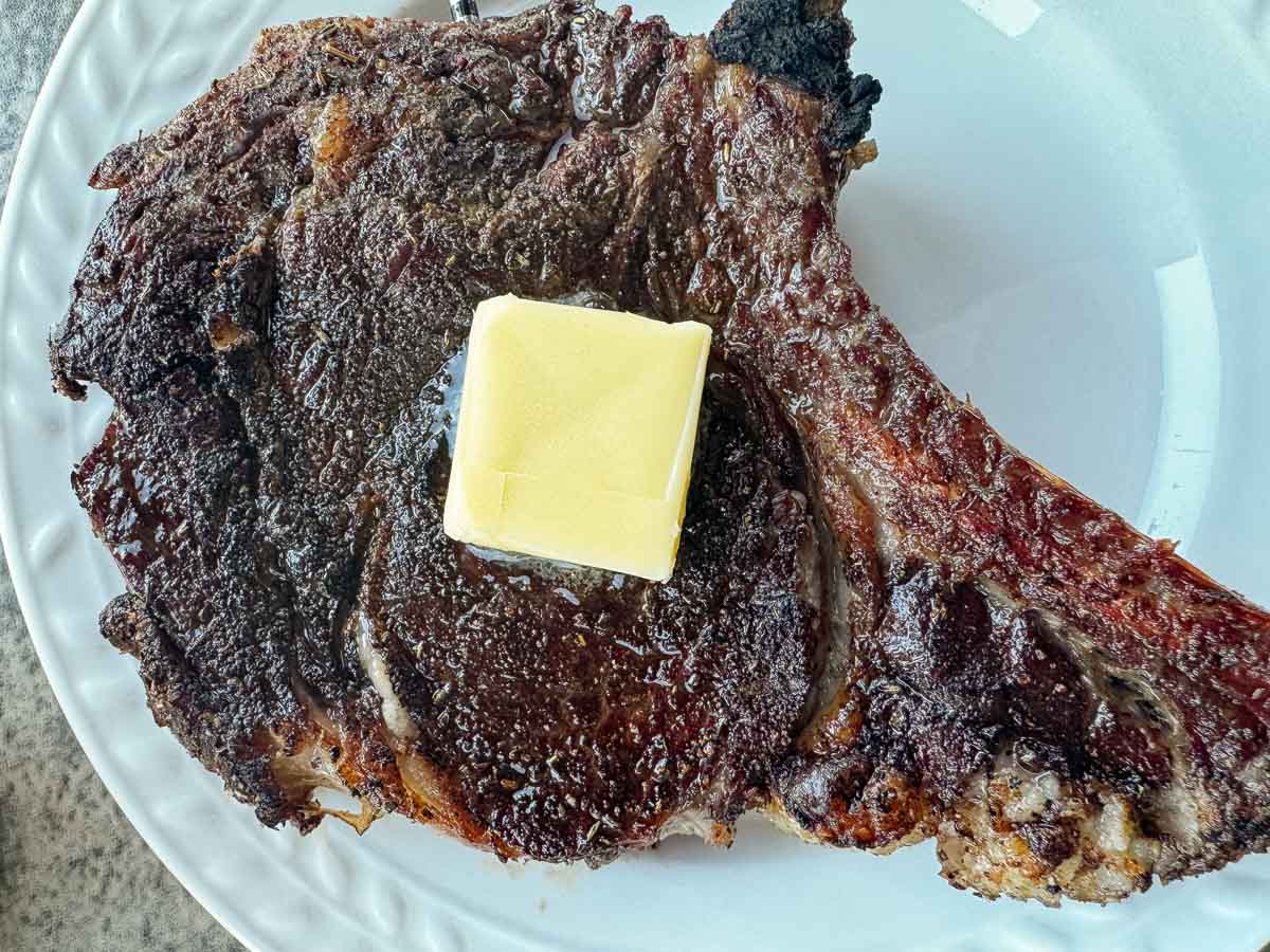 a smoked ribeye steak with a pat of butter.