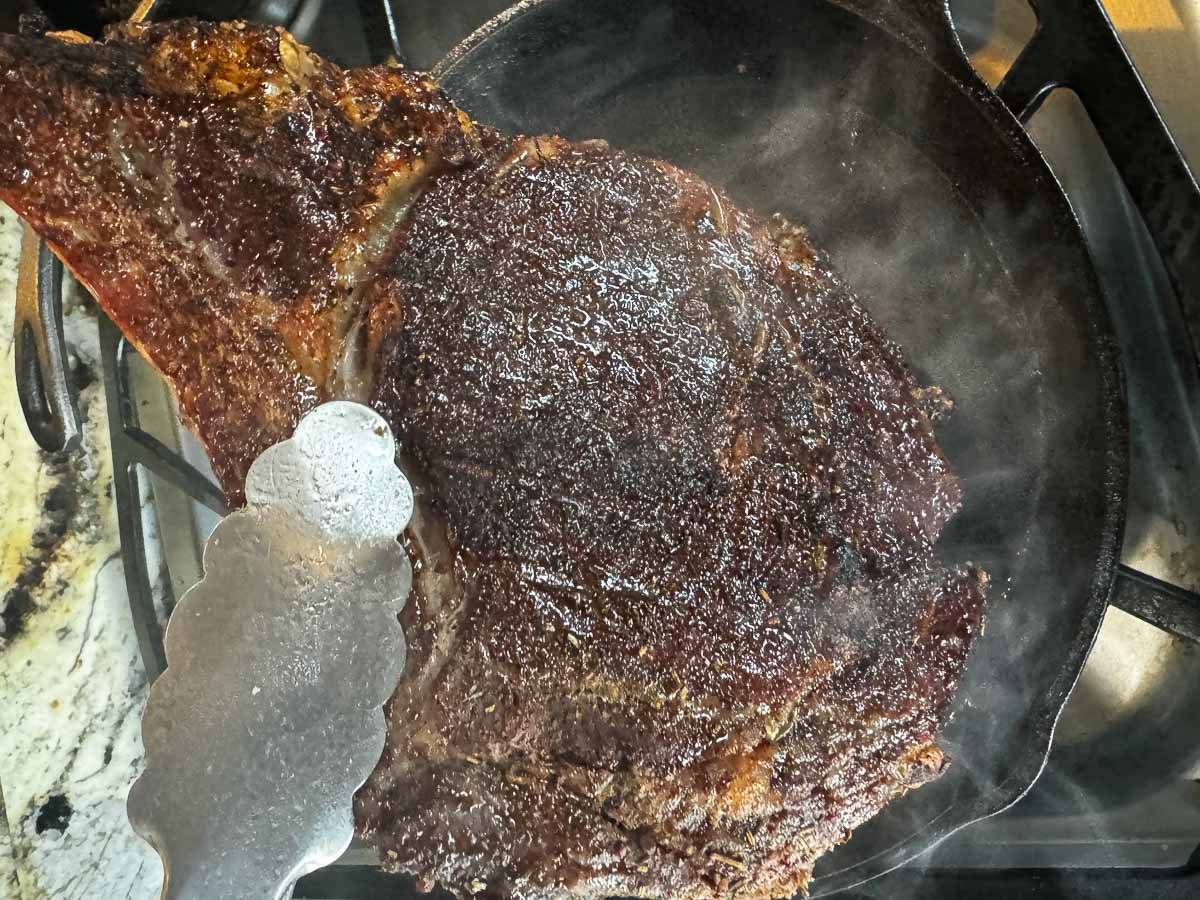 searing a smoked ribeye in a cast iron skillet. 