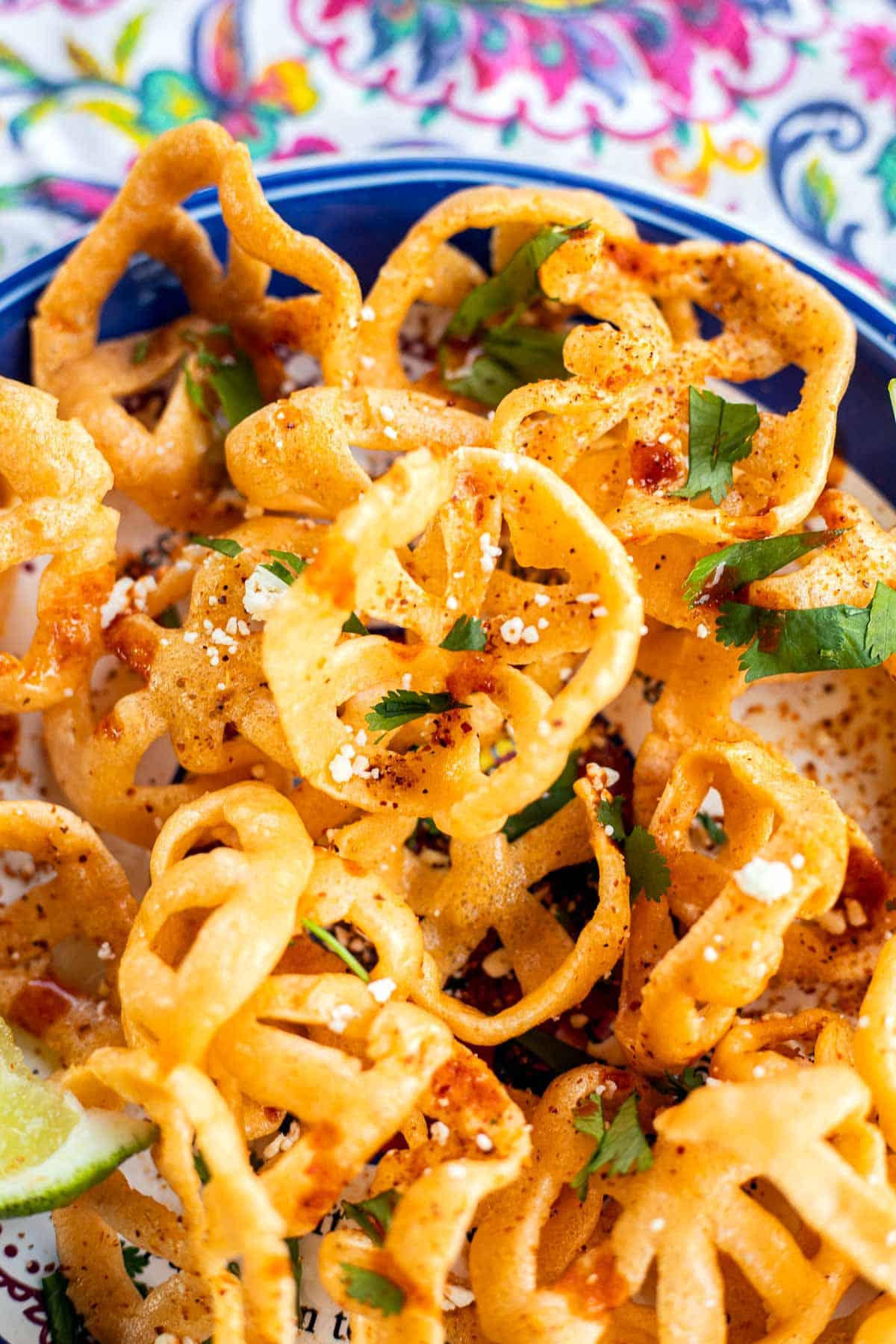 duritos with hot sauce, cheese, and chopped cilantro.