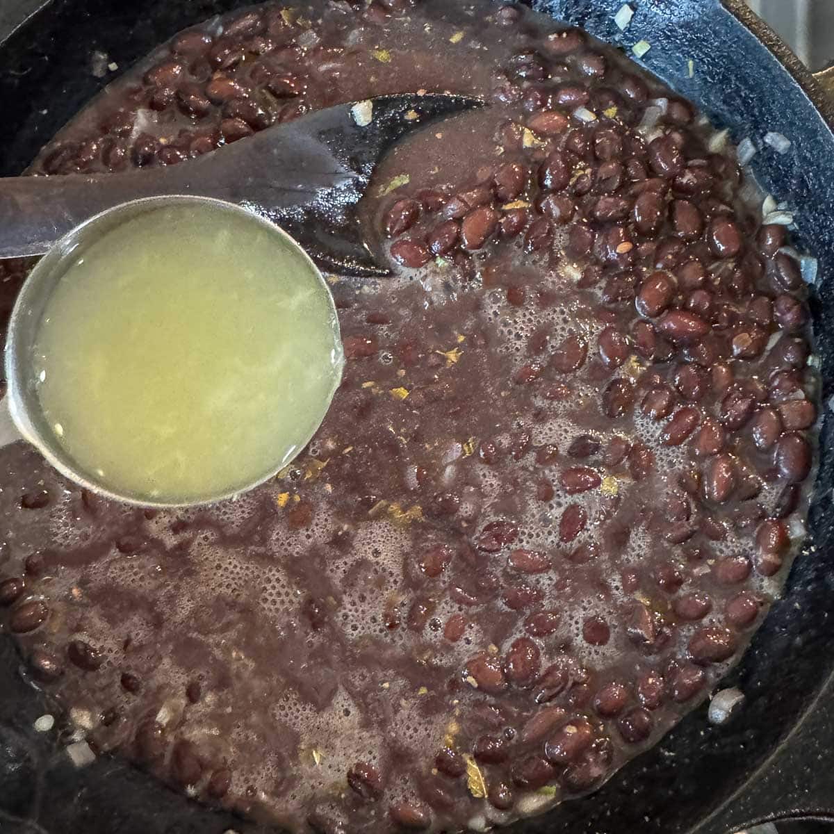 adding lime juice to mexican black beans. 